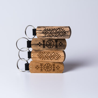 Atslēgu piekariņš ar latvju rakstu zīmēm. Izgatavots no ozola koka un dabīgās ādas.